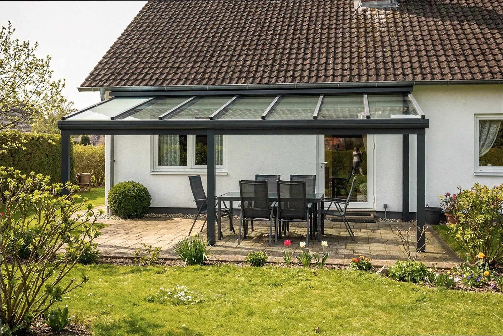 Moderne Terrassenüberdachung mit Glasdach an einem Wohnhaus in Aachen